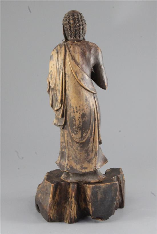 A Chinese brown lacquered wood figure of a luohan, 19th century, total height 38cm